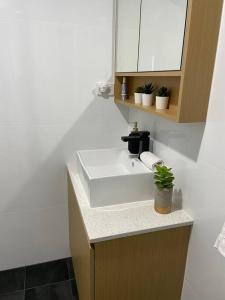 a bathroom with a white sink and a mirror at Marina Point in Sandstone Point