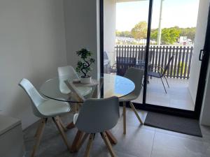 una sala da pranzo con tavolo e sedie e un balcone di Marina Point a Sandstone Point