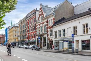 um homem a andar de bicicleta numa rua da cidade em Live on the roof of Oslo city center em Oslo