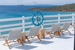 a row of chairs on a deck with the ocean at Hotel Perrakis in Kipri