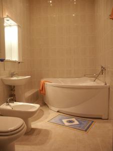 a bathroom with a toilet and a tub and a sink at Uspenskaya Hotel in Uglich