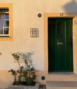 a green door on the side of a building at Casa Flor de Lis, Sardoal in Sardoal