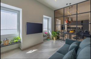a living room with a blue couch and a tv at New - Designer finished 1 Bedroom apartment A 5 minutes ferry away from Valletta in Mosta