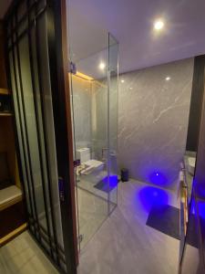uma casa de banho com um chuveiro e uma porta de vidro em Gwandalan House em Dipolog