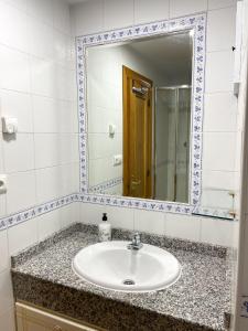 ein Bad mit einem Waschbecken und einem Spiegel in der Unterkunft AZ El Balcón de Luna in Saragossa