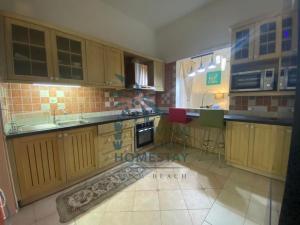 cocina con armarios de madera y suelo de baldosa en D'Wina Villa Homestay en Papar