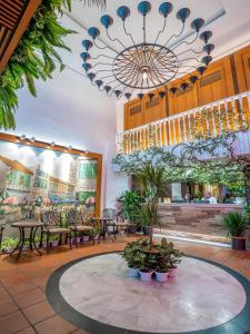 a restaurant with tables and chairs and a chandelier at Floresta Hotel Chinatown in Kuala Lumpur