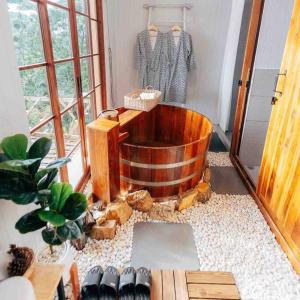 a wooden bath tub in a room with shoes at At The Mountain Cottage, Tiny Home at Doichang with Hot tub Included Breakfast and Dinner in Ban Huai Khai