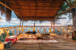 a porch with a hammock and a table on a deck at At The Mountain Cottage, Tiny Home at Doichang with Hot tub Included Breakfast and Dinner in Ban Huai Khai