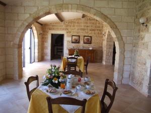 a dining room with a table with food on it at Agriturismo Masseria Chicco Rizzo in Sternatia