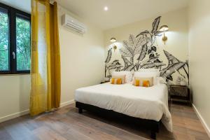 a bedroom with a large white bed with a plant wall at La Maison Roussel in Rosières +26 photos