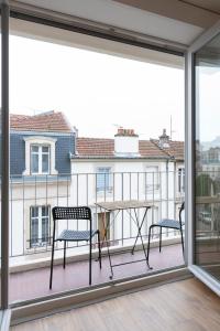 einen Balkon mit 2 Stühlen und einem Tisch in der Unterkunft Le Placieux avec parking privé in Nancy
