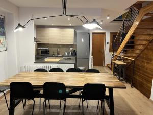 a dining room and kitchen with a wooden table and chairs at Chalet Los Ibones - Lodge Formigal in Formigal