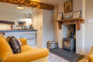 a living room with a couch and a wood stove at Cotswold Way Cottage in Stroud