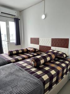 - une chambre avec 2 lits et des oreillers dans l'établissement Apartment Grand Sentraland Karawang Manage by Laguna Room, à Karawang