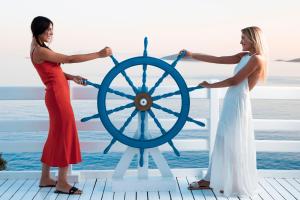 two women playing with a ship wheel on a dock at Hotel Perrakis in Kipri