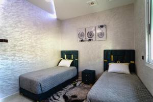 sypialnia z 2 łóżkami w pokoju w obiekcie Appartement moderne quartier calme w Fezie