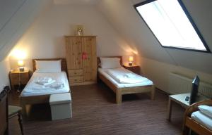 a attic room with two beds and a window at Tepe's Gasthof in Schwarmstedt