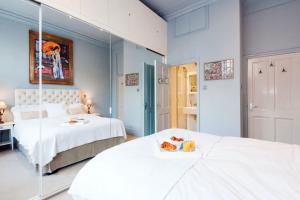 ロンドンにあるTREE HOUSE Celebrity Residence in Notting Hillのベッドルーム1室(ベッド2台、鏡付)