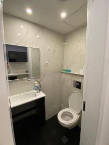 ein Badezimmer mit einem weißen WC und einem Waschbecken in der Unterkunft Rothschild 79 in Petach Tikwa