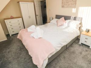 a bedroom with a bed with towels on it at Fuschia Cottage in Whitby
