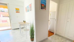 a white kitchen with a table and a refrigerator at La Couronne du Cros in Cagnes-sur-Mer