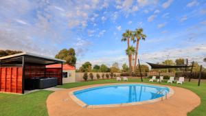 a swimming pool in the middle of a yard at Motel Meneres in Corowa