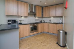 cocina con armarios de madera y encimera en Charming 1 bedroom flat in Liverpool City Centre en Liverpool