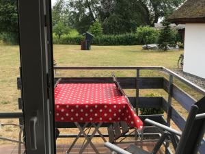 a red table with white polka dots sitting on a balcony at Pension Martens - Ella in Wieck +2 photos