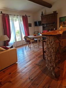 sala de estar con mesa y chimenea de piedra en Petit gite de Provence, en Mazan