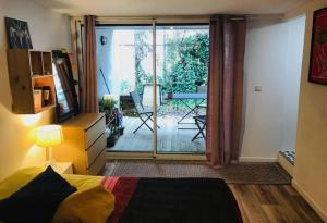 ボルドーにあるChambre Darwin SDB WC et Terrasse privésのベッドルーム1室(ベッド1台付)、スライド式ガラスドアが備わります。