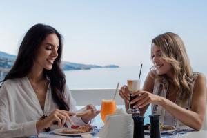 two women sitting at a table eating food at Hotel Perrakis in Kipri