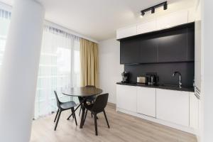 cocina con mesa y sillas en una habitación en Sea Waves Apartament Resort & SPA 428B by Renters en Międzyzdroje