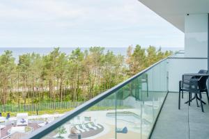 a glass balcony with a view of the ocean at Sea Waves Apartament Resort & SPA 428B by Renters in Międzyzdroje