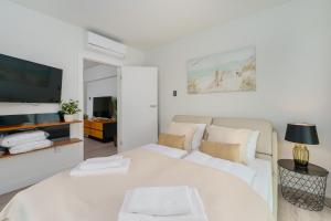 ein weißes Wohnzimmer mit einem Sofa und einem TV in der Unterkunft Sea Waves Apartament Resort & SPA 428B by Noclegi Renters in Misdroy + 34 Fotos