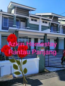 a sign in front of a building with a red rose at Sobey Laris Homestay RANTAU PANJANG in Pasir Mas