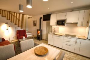 cocina y sala de estar con mesa y fogones en Casa Rural La Cortina, en Pandiello