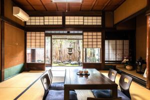 a dining room with a wooden table and chairs at Tansada Heritage Machiya in Kyoto