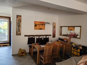 ein Wohnzimmer mit einem Tisch und einem Schreibtisch sowie einem Tisch und Stühlen in der Unterkunft Rheinblick Waldshut 2 in Waldshut-Tiengen