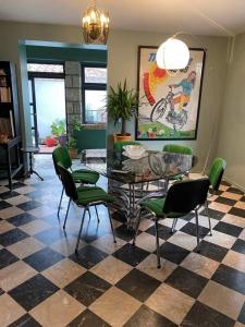 sala de estar con mesa de cristal y sillas verdes en LA CASA SANILLS, en Saint-Hippolyte