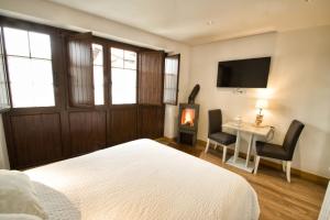 a bedroom with a bed and a desk and a television at Casa Rural La Cortina in Pandiello