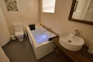 ein Badezimmer mit einer Badewanne, einem Waschbecken und einem WC in der Unterkunft Casa Rural La Cortina in Pandiello