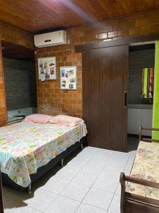 a bedroom with a bed and a brick wall at GRAVATÁ-PE- CASA 4 QUARTOS in Gravata