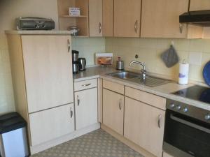 a small kitchen with a sink and a stove at Zur-Alten-Volksbank-Wohnung-2 in Petersdorf auf Fehmarn