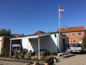Ein weißes Haus mit einer Flagge darüber in der Unterkunft Zur Alten Volksbank Wohnung 2 in Petersdorf auf Fehmarn