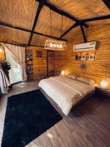 una camera da letto con un grande letto in una camera in legno di منتجع اكواخ النخيل a Al Muţayrifī