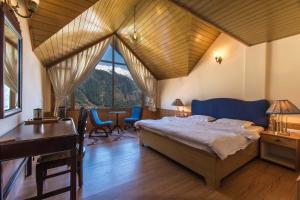 a bedroom with a bed and a desk in a room at StayVista at Jodhpur House - 3 BR Pet friendly Cozy villa in Manali in Manāli