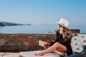 a woman sitting on a bench talking on a cell phone at Hotel Perrakis in Kipri