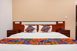 un letto con una coperta colorata sopra di FabHotel Shubh Shaleen Springs a Bhopal
