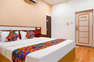 una camera da letto con un grande letto con cuscini colorati di FabHotel Shubh Shaleen Springs a Bhopal